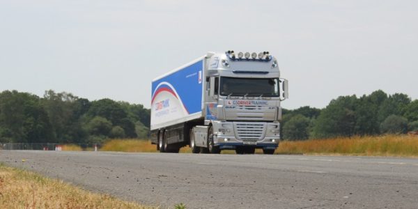 HGV truck driving on a rural road, representing practical training for HGV driving tests and career opportunities in heavy goods vehicle transportation.